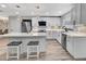 A modern, sleek kitchen with stainless steel appliances, white cabinets, and a spacious island at 6829 Bittersweet Ln, Orlando, FL 32819
