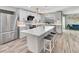 A modern, sleek kitchen with stainless steel appliances, white cabinets, and a spacious island at 6829 Bittersweet Ln, Orlando, FL 32819