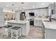 A modern, sleek kitchen with stainless steel appliances, white cabinets, and a spacious island at 6829 Bittersweet Ln, Orlando, FL 32819