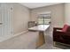This home office boasts a bright window, designer desk, and comfortable seating space at 6829 Bittersweet Ln, Orlando, FL 32819