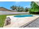 Relaxing pool with concrete deck, a wooden bench, and a white fence, creating a private backyard retreat at 6829 Bittersweet Ln, Orlando, FL 32819