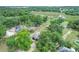 Aerial view of property showcasing the home, lush greenery, outbuildings, and neighborhood at 8634 Garden Way Rd, Groveland, FL 34736