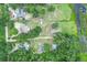 Aerial view showcases multiple houses within wooded properties plus pond area in the neighborhood at 8634 Garden Way Rd, Groveland, FL 34736