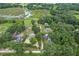 An aerial view of multiple houses surrounded by dense trees, near a waterway at 8634 Garden Way Rd, Groveland, FL 34736