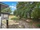 Backyard view with a fence, red barn, and trees at 8634 Garden Way Rd, Groveland, FL 34736