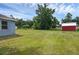Spacious backyard showing a home, shed, and large open grassy area at 8634 Garden Way Rd, Groveland, FL 34736