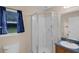 Bright bathroom featuring a glass shower, and sink with blue countertop at 8634 Garden Way Rd, Groveland, FL 34736