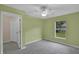 Spacious bedroom with a window, open door, ceiling fan, and green walls at 8634 Garden Way Rd, Groveland, FL 34736