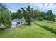 Aerial view of a blue home with an attached garage and a large, well-manicured lawn at 8634 Garden Way Rd, Groveland, FL 34736