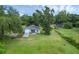Aerial view of a charming blue home featuring an attached garage and a lush green lawn at 8634 Garden Way Rd, Groveland, FL 34736