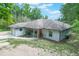 Charming home exterior featuring a red front door, white trim, and a covered front porch at 8634 Garden Way Rd, Groveland, FL 34736