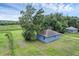 Aerial view of a blue home on an expansive lawn surrounded by trees at 8634 Garden Way Rd, Groveland, FL 34736