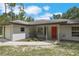 Charming single-story home featuring a red front door and an attached one-car garage at 8634 Garden Way Rd, Groveland, FL 34736