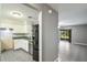 Kitchen view with white cabinets, stainless steel appliances, and an open view into the living area at 8634 Garden Way Rd, Groveland, FL 34736