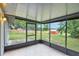 Relax in this screened patio with a view of the backyard, featuring a wooden fence and red shed at 8634 Garden Way Rd, Groveland, FL 34736