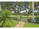 Scenic backyard view through a black metal gate with manicured landscaping of a golf course at 9433 San Miguel, Howey In The Hills, FL 34737
