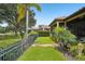 Well-manicured backyard with lush green lawn, palm trees, and wrought iron fence facing golf course at 9433 San Miguel, Howey In The Hills, FL 34737