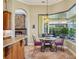 Cozy breakfast nook featuring granite countertops, seamless window views to a private outdoor patio, and stone fireplace at 9433 San Miguel, Howey In The Hills, FL 34737