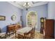 Charming dining room with wooden furniture, chandelier, and ample natural light from the large arched window at 9433 San Miguel, Howey In The Hills, FL 34737