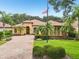 Beautiful Mediterranean-style home with meticulously maintained landscaping and lush green lawn at 9433 San Miguel, Howey In The Hills, FL 34737