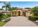 Stunning Mediterranean-style home featuring a tile roof, arched entry, and brick paver driveway at 9433 San Miguel, Howey In The Hills, FL 34737