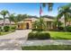 Charming home featuring lush landscaping, a paver driveway, and well-maintained lawn at 9433 San Miguel, Howey In The Hills, FL 34737