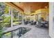 This covered lanai has brick pavers, wood ceilings, and seating areas with a pool at 9433 San Miguel, Howey In The Hills, FL 34737