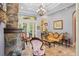 Elegant living room with a stone fireplace, decorative chandelier, and stylish furniture creating a cozy atmosphere at 9433 San Miguel, Howey In The Hills, FL 34737