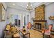 Elegant living room with stone fireplace, chandelier, and classic furnishings in a comfortable and inviting space at 9433 San Miguel, Howey In The Hills, FL 34737