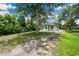 Charming exterior view with mature trees creating a peaceful setting at 1134 Cr 464, Lake Panasoffkee, FL 33538