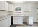 The kitchen has white cabinets, gray flooring, and light countertops at 1134 Cr 464, Lake Panasoffkee, FL 33538