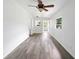 Bright living room with modern gray wood flooring and ceiling fan at 1134 Cr 464, Lake Panasoffkee, FL 33538