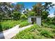 Backyard shed surrounded by foliage and a small walkway at 1134 Cr 464, Lake Panasoffkee, FL 33538