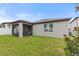 View of the home's back exterior featuring a screened porch and lawn at 120 Citrus Isle St, Davenport, FL 33837