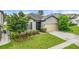 Well-kept single-Gathering home with lush lawn, gray exterior, and attached two-car garage at 120 Citrus Isle St, Davenport, FL 33837