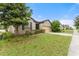Single story house with nicely landscaped lawn and neutral color scheme at 120 Citrus Isle St, Davenport, FL 33837
