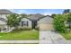 Charming home exterior featuring gray siding, stone accents, well-manicured lawn and landscaping at 120 Citrus Isle St, Davenport, FL 33837