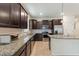 The kitchen features dark wood cabinets, granite countertops, stainless steel appliances and a spacious island at 120 Citrus Isle St, Davenport, FL 33837