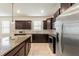 Spacious kitchen with stainless steel appliances, dark wood cabinets and a granite countertop island at 120 Citrus Isle St, Davenport, FL 33837