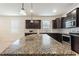 Spacious kitchen with large granite island, pendant lighting, and dark cabinets offering a perfect space for cooking and entertaining at 120 Citrus Isle St, Davenport, FL 33837
