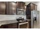 The kitchen is equipped with stainless steel appliances and dark wood cabinetry for a sleek modern look at 120 Citrus Isle St, Davenport, FL 33837