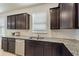 The kitchen features dark wood cabinets, granite countertops, stainless steel dishwasher and a double basin sink at 120 Citrus Isle St, Davenport, FL 33837