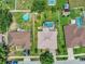 Aerial view showcasing three homes, each with unique pools and well-maintained green lawns at 1216 Cheshire St, Groveland, FL 34736