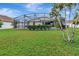 Green backyard featuring a screened-in patio at 1216 Cheshire St, Groveland, FL 34736
