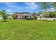 Extensive backyard with a screened-in pool area surrounded by a lush green lawn and privacy fence at 1216 Cheshire St, Groveland, FL 34736