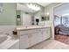 Well-lit bathroom with a double vanity, spacious countertop, and access to an adjacent bedroom at 1216 Cheshire St, Groveland, FL 34736