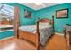 Cozy bedroom featuring a wood frame bed, wooden floors, and view to an enclosed pool area at 1216 Cheshire St, Groveland, FL 34736