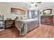 Bedroom featuring hardwood floors, a ceiling fan and a view of the outside through the windows at 1216 Cheshire St, Groveland, FL 34736