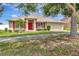 Charming single-story home featuring a red front door, red shutters, and well-manicured landscaping at 1216 Cheshire St, Groveland, FL 34736