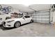 Clean garage with a white car, tool rack, and overhead storage racks at 1216 Cheshire St, Groveland, FL 34736